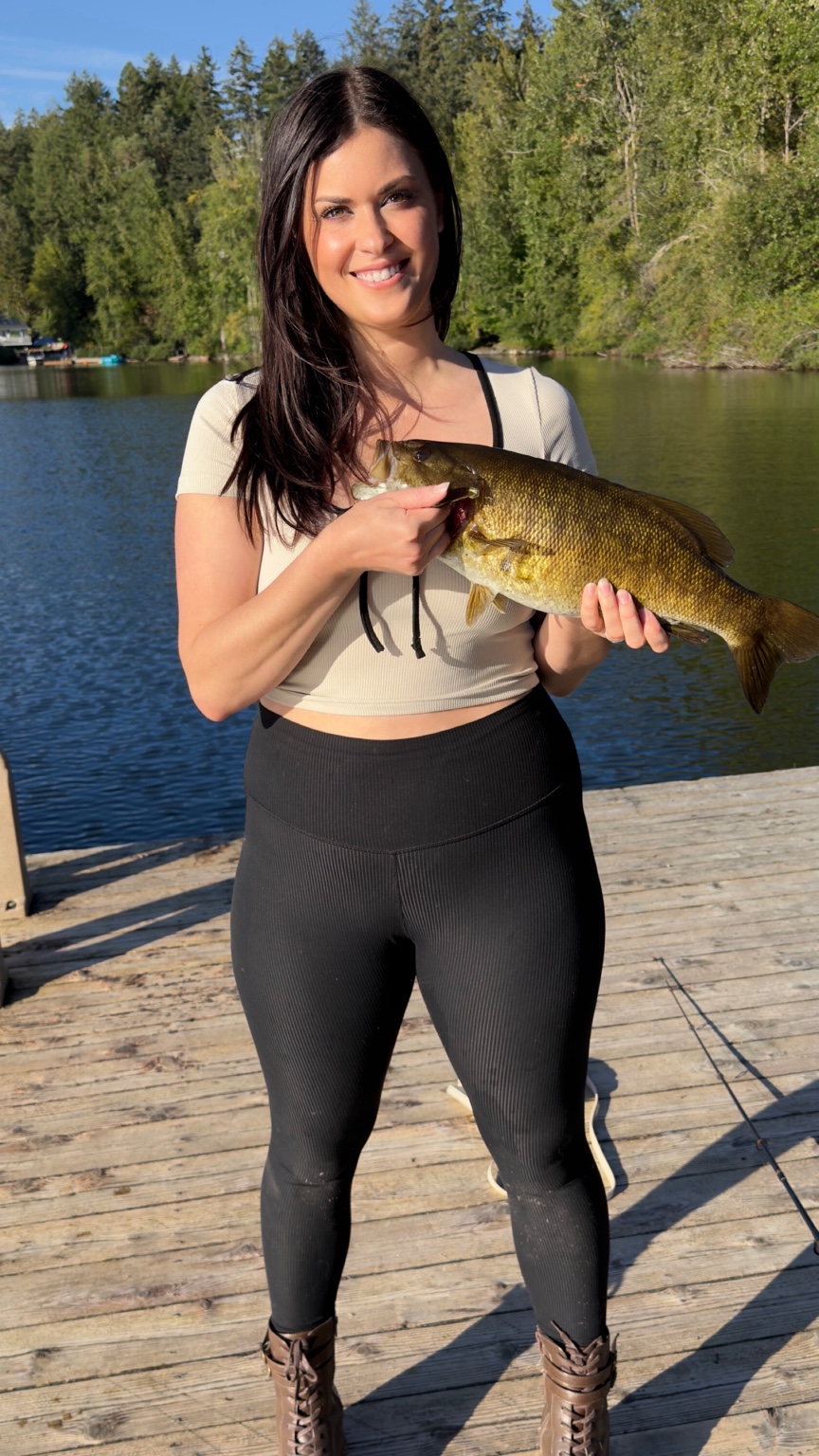 Holding a freshly caught fish on a lakeside dock